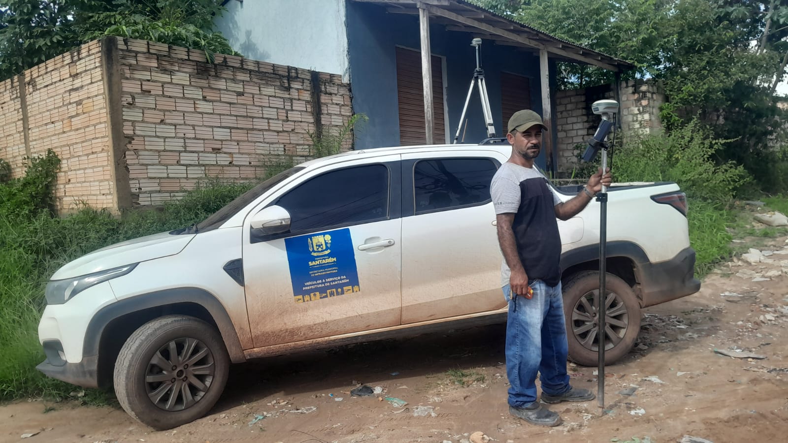 Técnico com receptor GNSS ao lado da picape