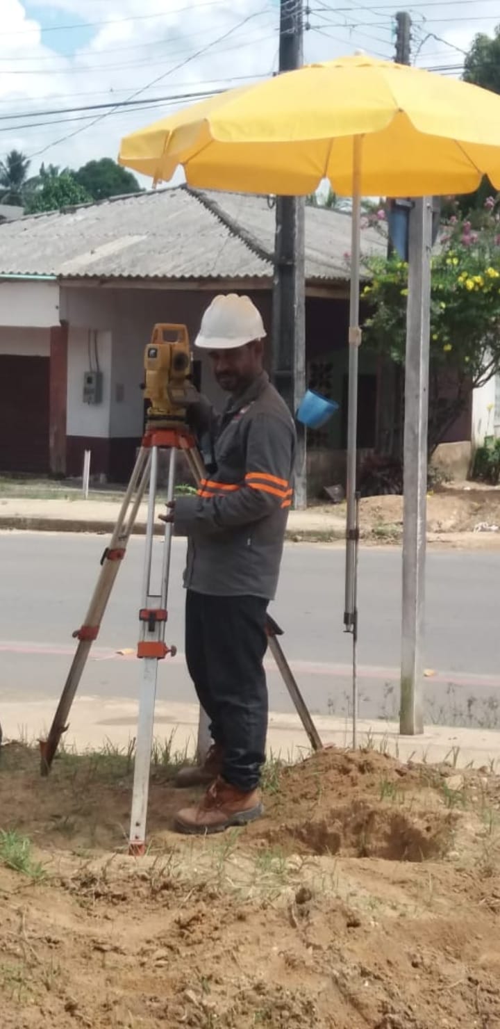 Topógrafo operando teodolito sobre tripé em obra