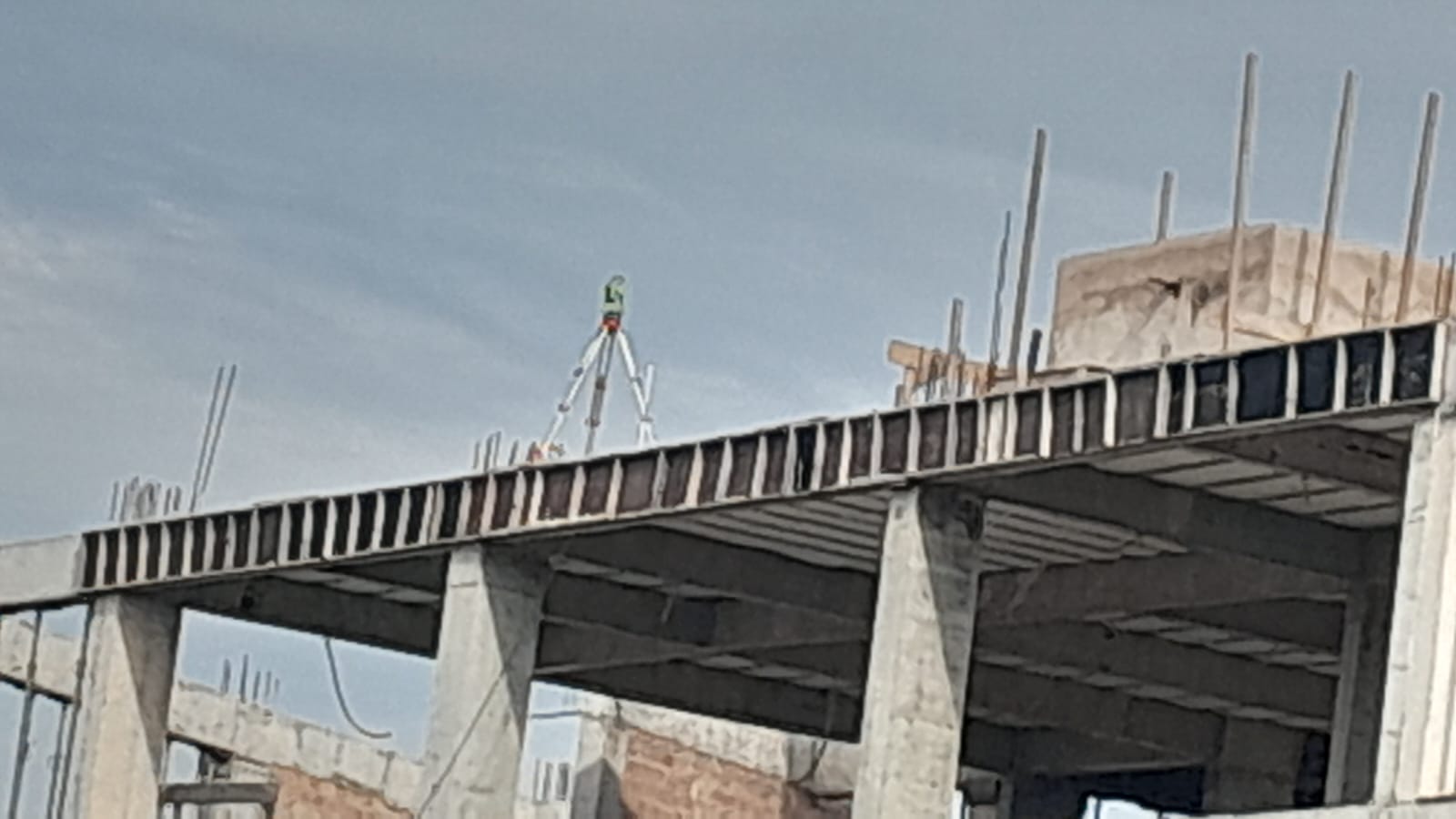 Instrumento de topografia a laser no topo de prédio em construção